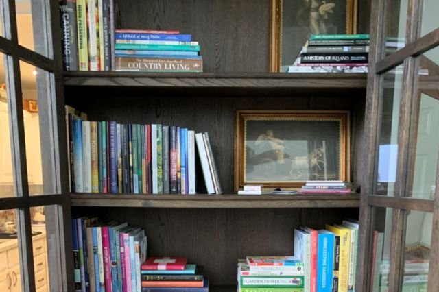 books and framed pictures on a bookcase